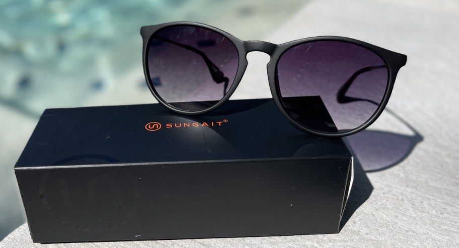 sungait glasses on top of their box displayed near the pool
