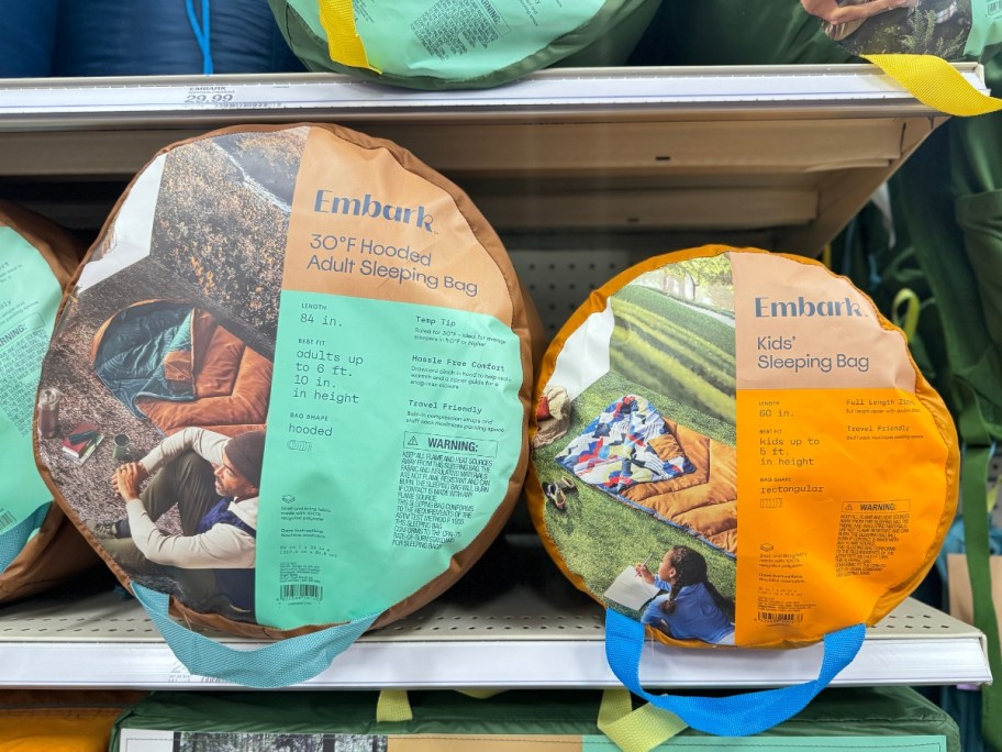 kids and adults sleeping bags in packaging on store shelf