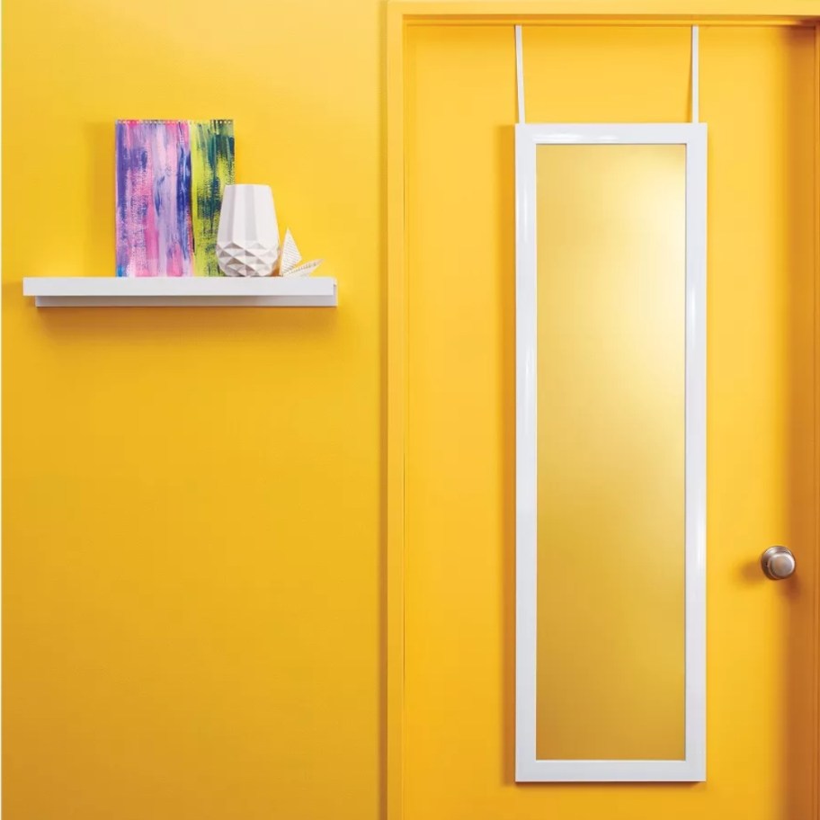 white over the door mirror on a yellow door