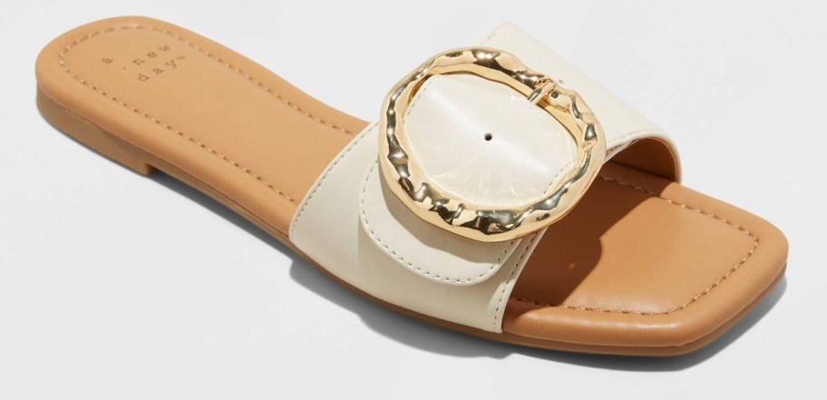 white slide sandals with circle buckle