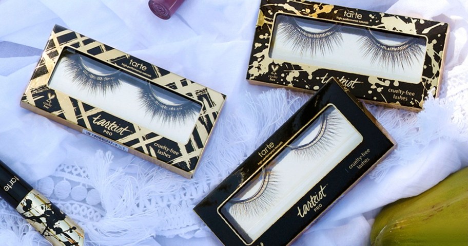 3 boxes of Tarte false eyelashes on a lace fabric with other Tarte eye products around them