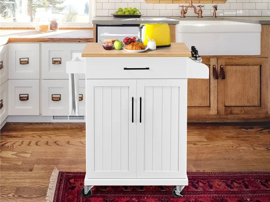 white kitchen island on wheels with food on top