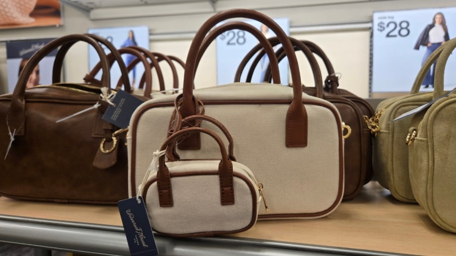 a cream colored canvas satchel bag and matching mini bag charm