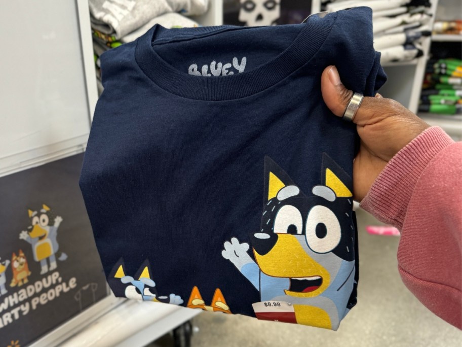 hand holding a folded up Bluey t-shirt in Walmart
