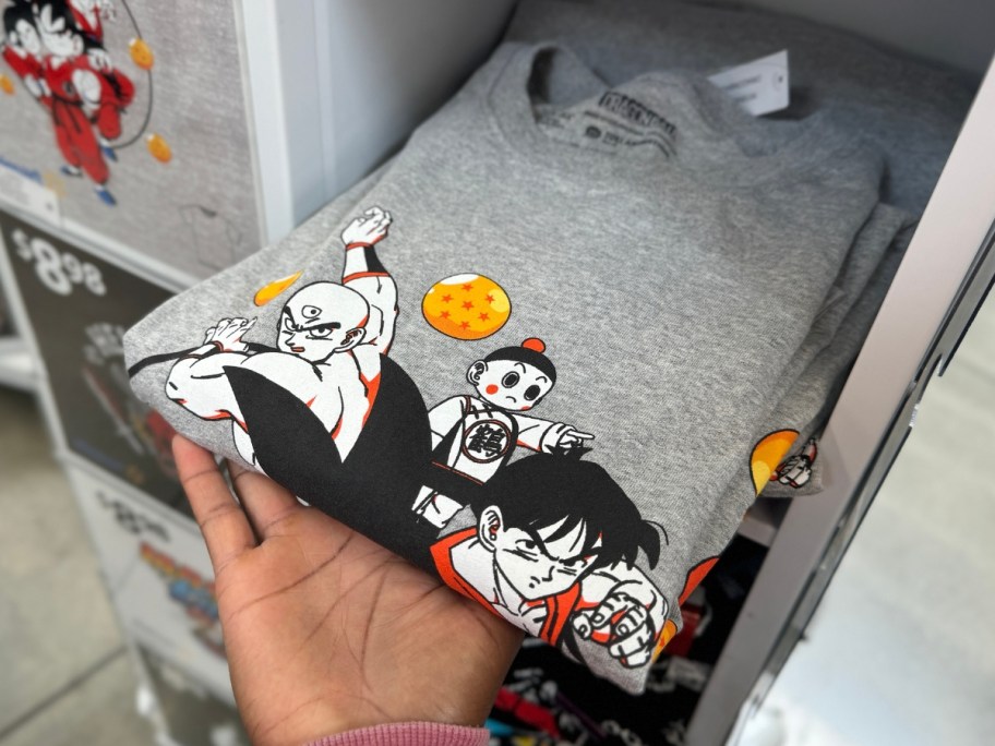 hand holding a Dragon Ball Z graphic tee from a display in Walmart