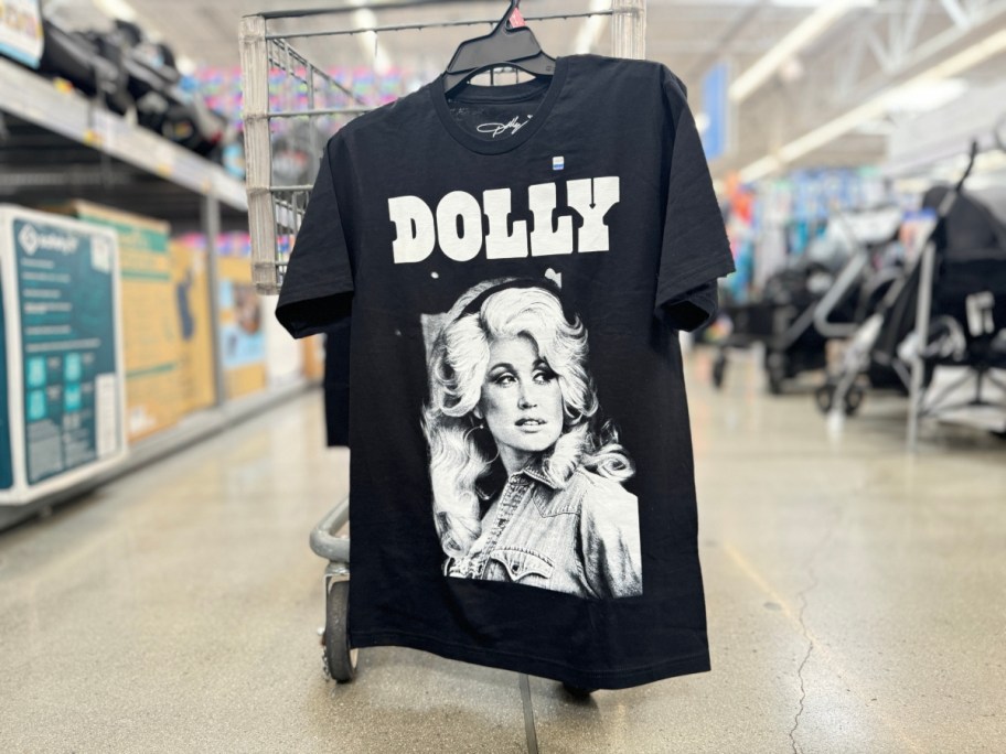 Dolly Parton graphic t-shirt hanging on a Walmart cart in store