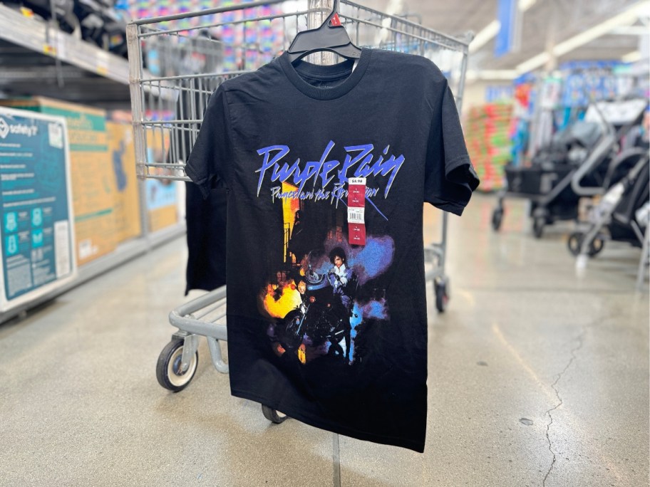 Prince Purple Rain graphic t-shirt hanging on a Walmart cart in store