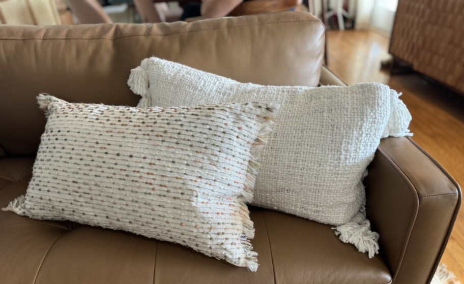 two white oblong throw pillowed stacked on a couch