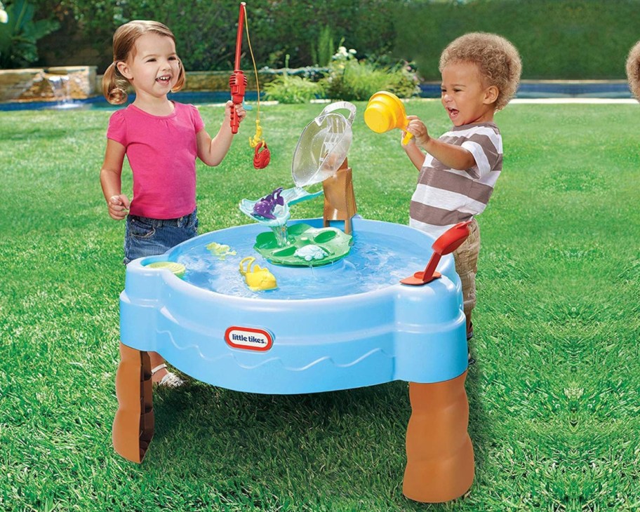 two kids playing at pond water table