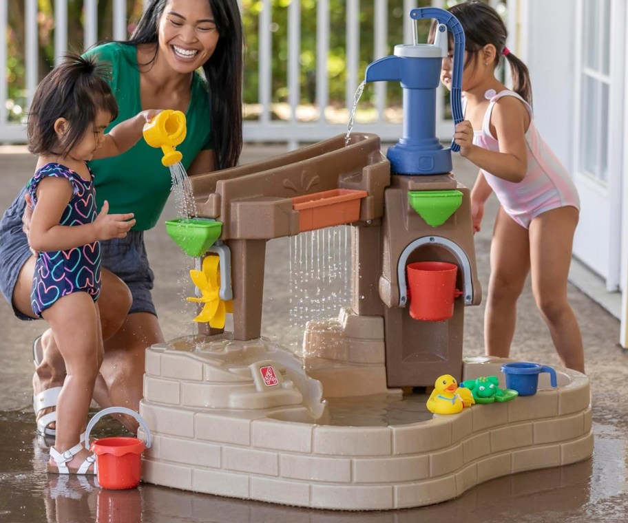 mom and kids playing at water table
