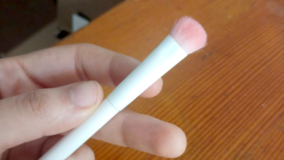 holding a white makeup brush
