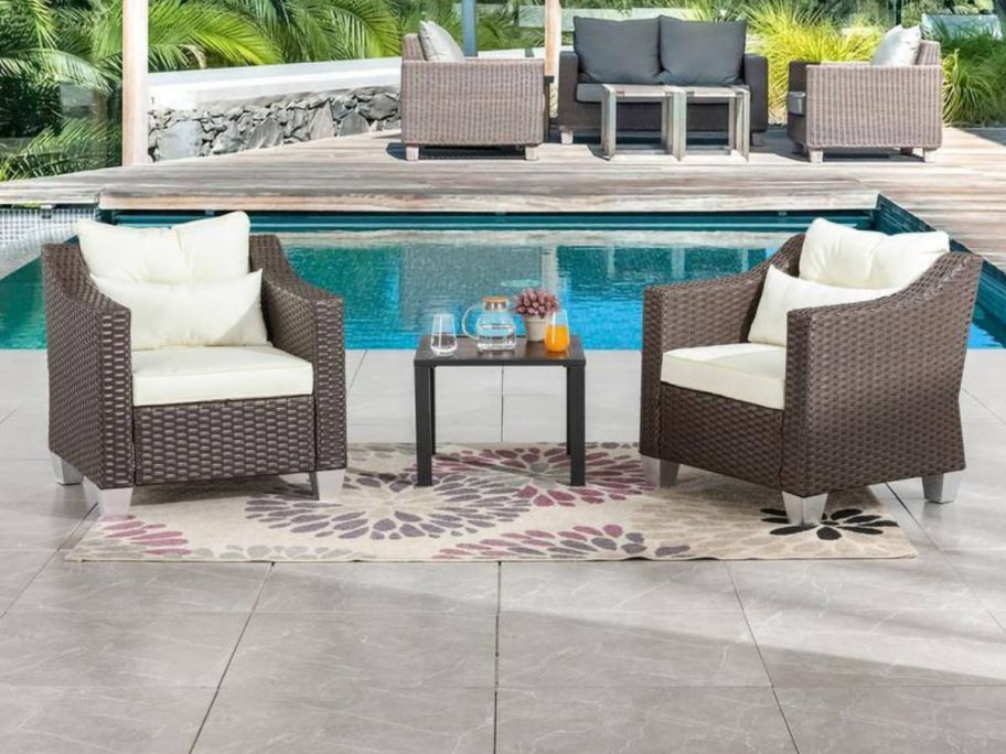 3-Piece Wicker Patio Conversation Set with Beige Cushions by pool