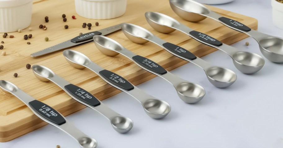 measuring spoons laying across cutting board on table