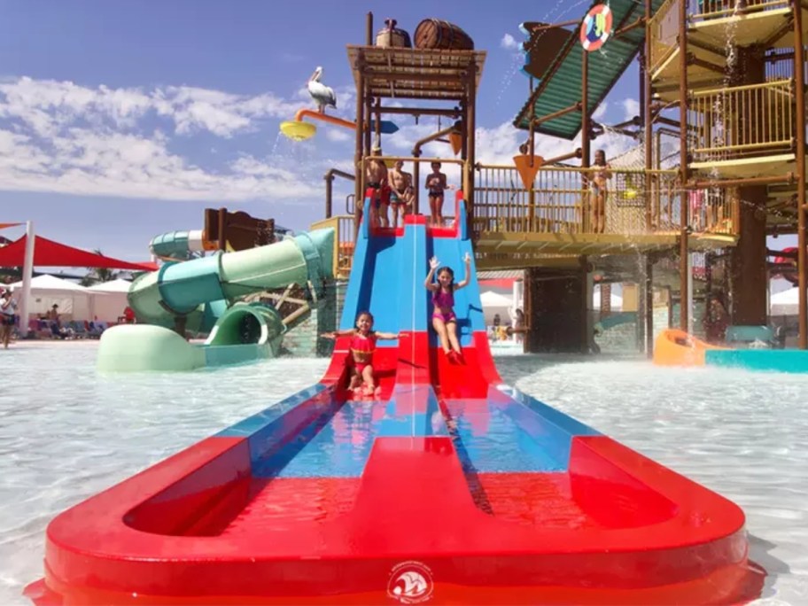 people going down red and blue waterslides at a waterpark