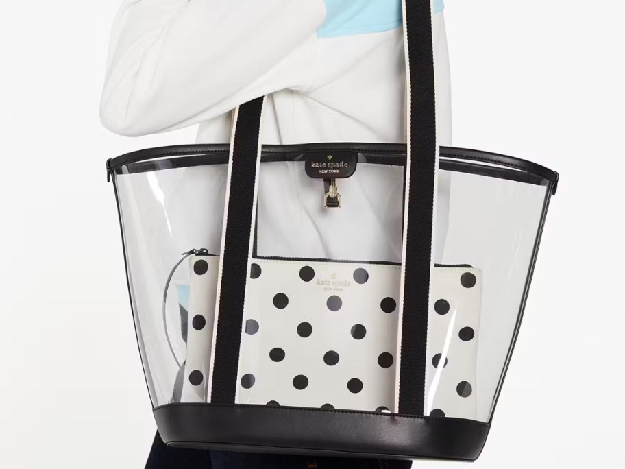 woman carrying a large clear and black Kate Spade tote with a white and black polka dot zipper bag inside