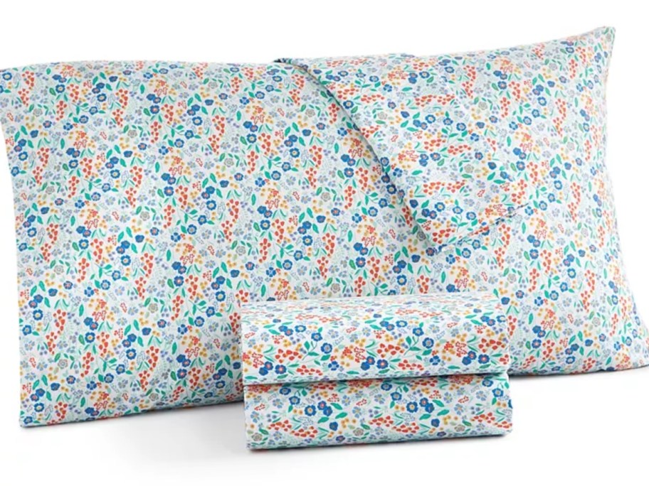 bed pillow with floral pillowcase and sheet set in front of it