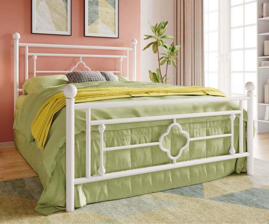 a white metal framed bed with headboard and footboard