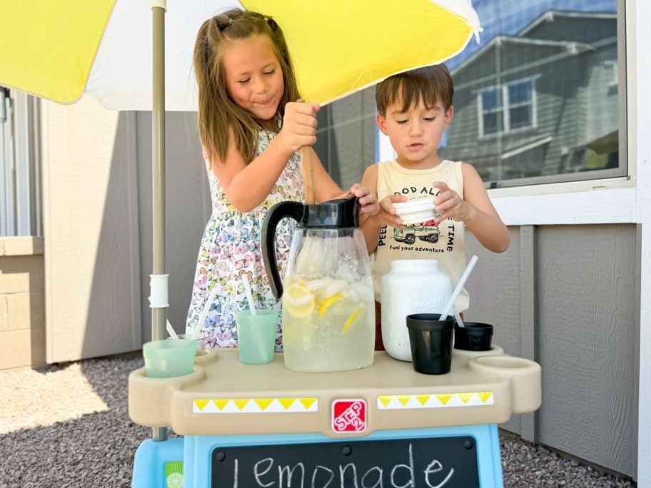 A little girl and boy making Lemonade on a Step 2 Lemonade stand