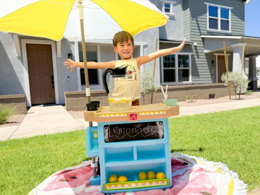 Little boy playing with a Step2 Lemonade Stand