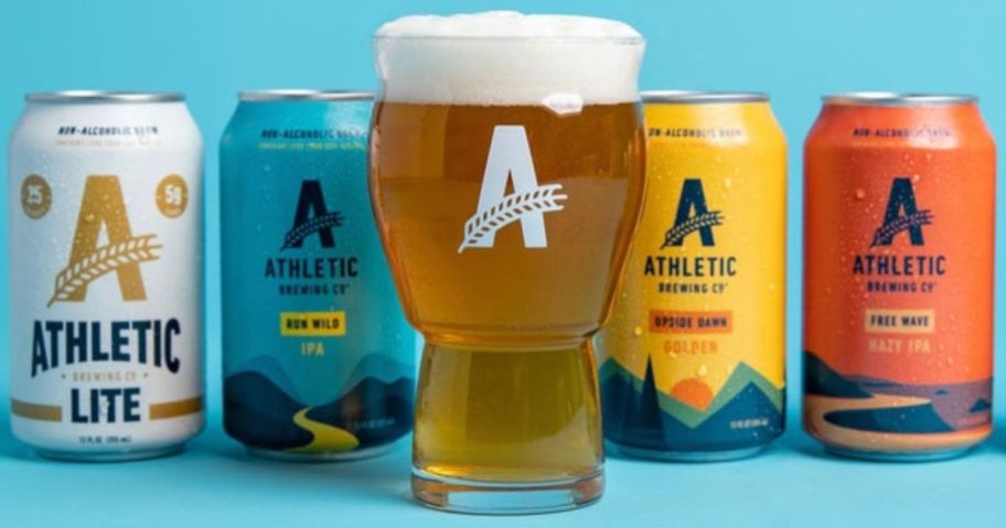 4 cans of Athletic Brewing Co. Non-Alcoholic beer and a logo glass filled with beer