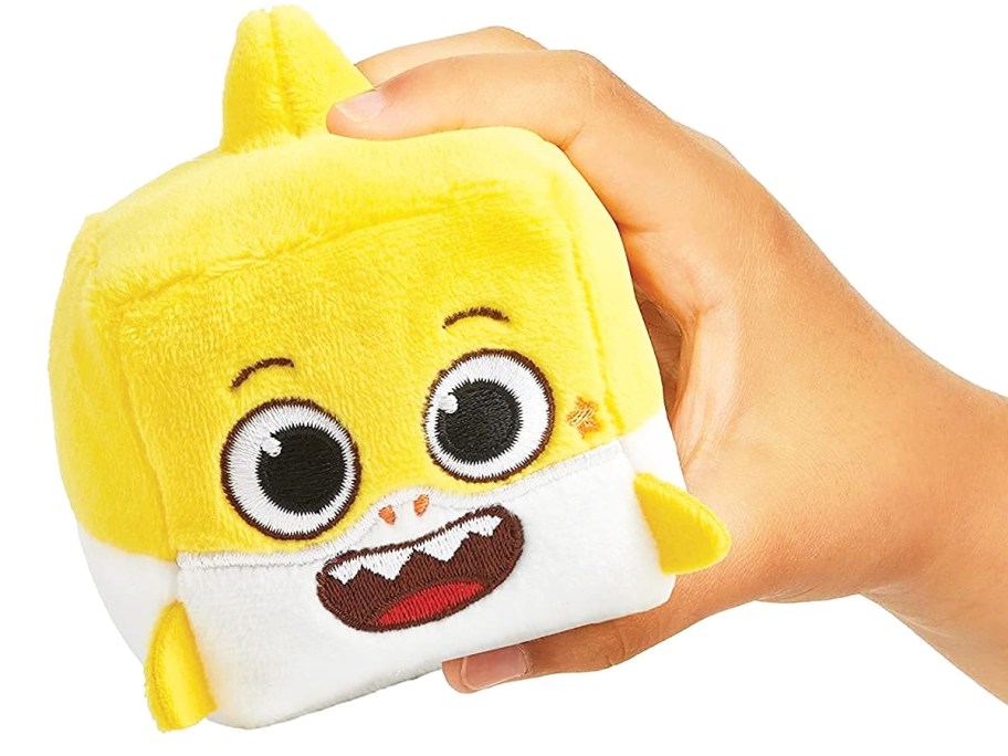 hand holding yellow baby shark plush cube