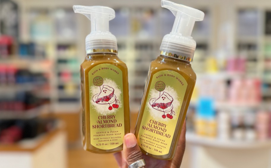 hand holding two bottles of pie-scented hand soap