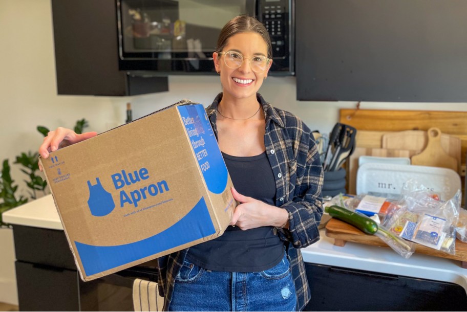 woman holding blue apron meal delivery box