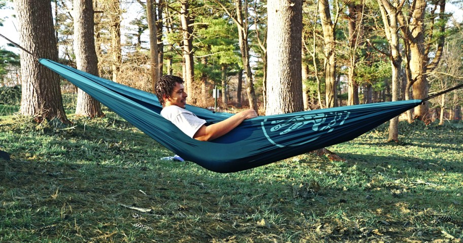 man sitting in a teal hammock