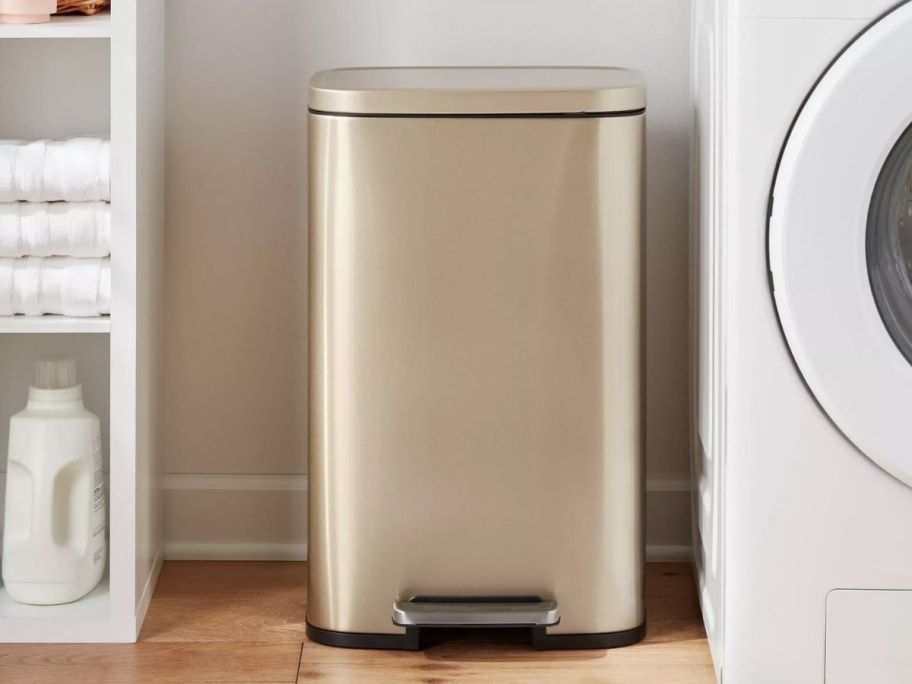a gold colored stainless steel step trash can