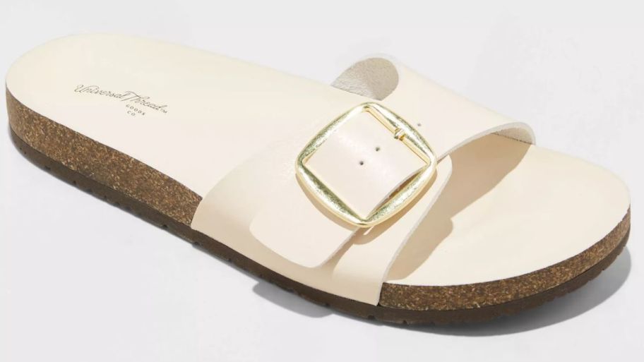 an ivory single strap footbed sandal with a large buckle