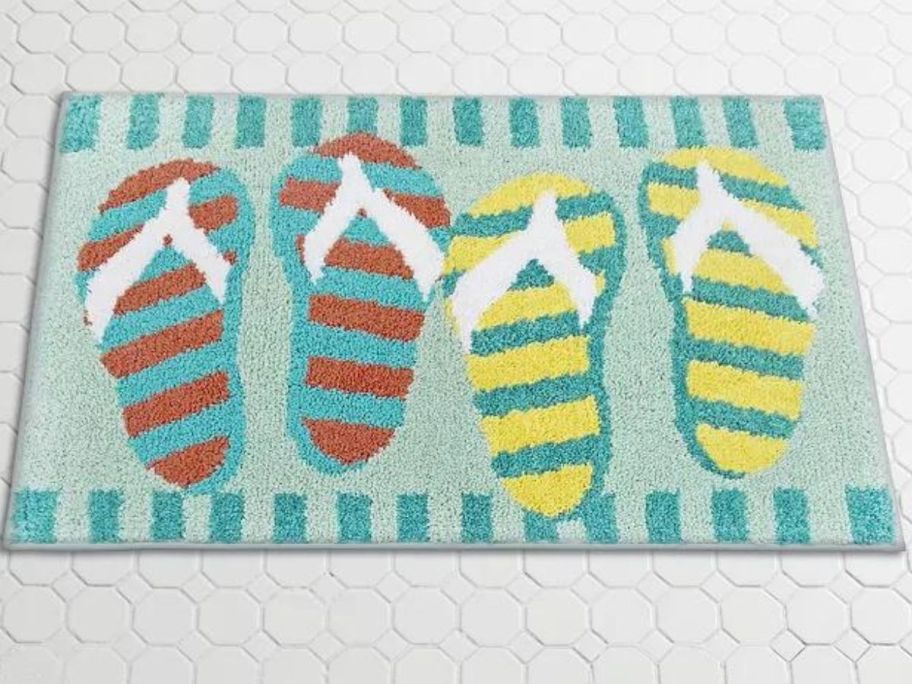 An accent rug with two pairs of flip flops on it