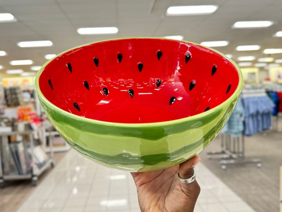 Hand holding up a watermelon serving bowl