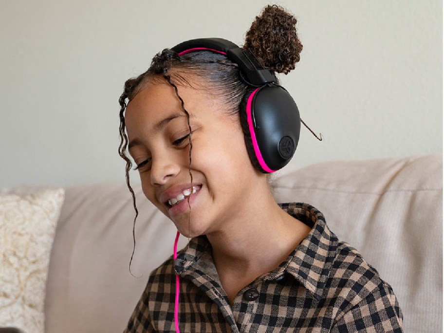 Child wearing overhead headphones in pink and black