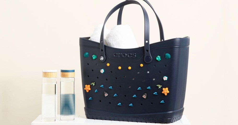 black tote bag decorated with crocs charms