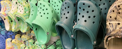 green crocs on display wall in store