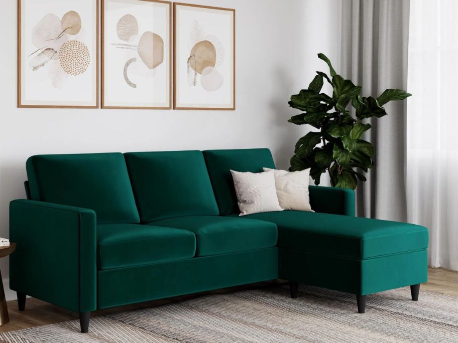 a dark green velvet upholstered sectional sofa