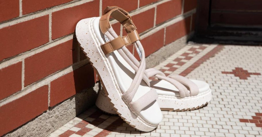 pair of platform sandals leaning against a brick wall