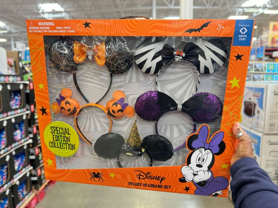 hand holding Disney Halloween 5-Piece Ears Deluxe Headband Set box in store