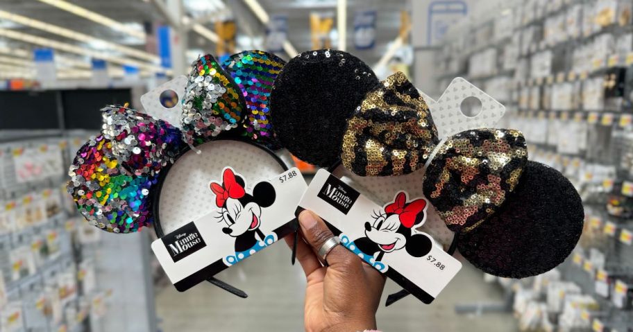 A person holding 2 pairs of Minnie Mouse Ears headband with sequins