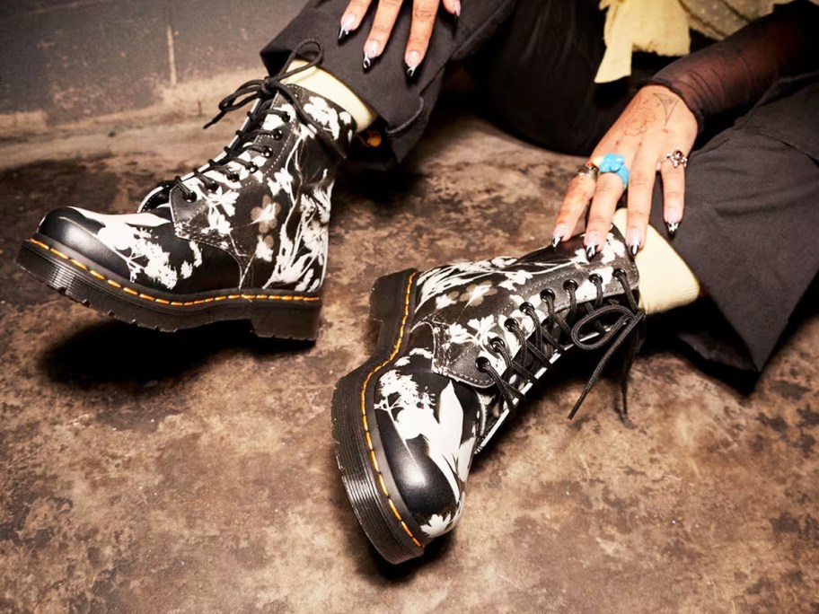 person wearing black and white floral print boots