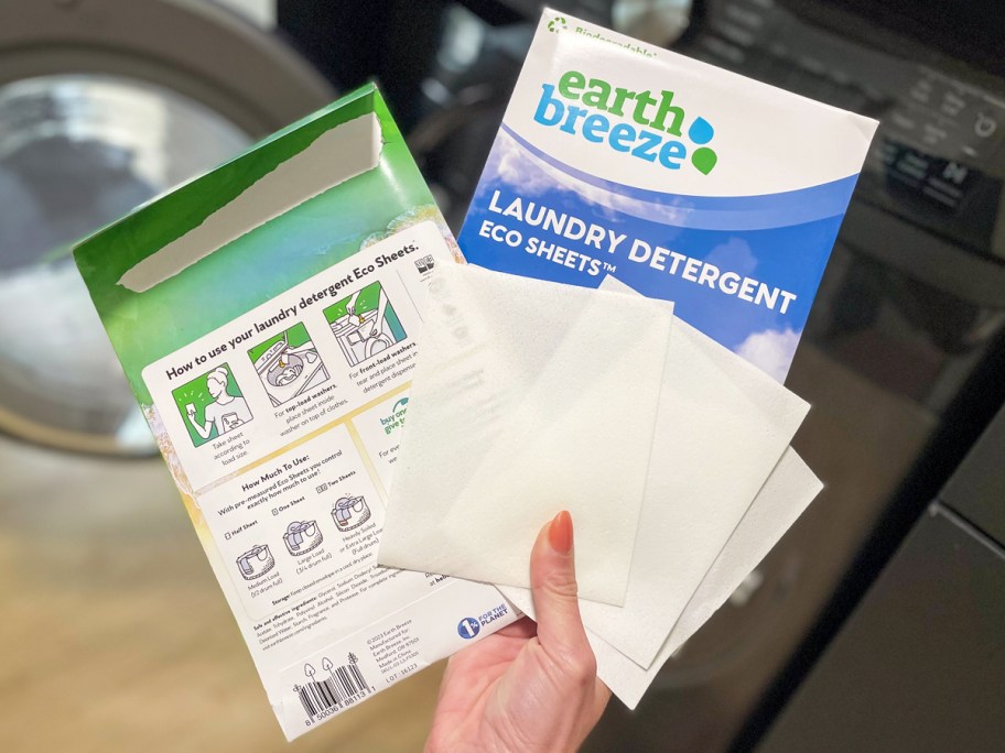 hand holding up two packs of Earth Breeze Laundry Detergent Sheets