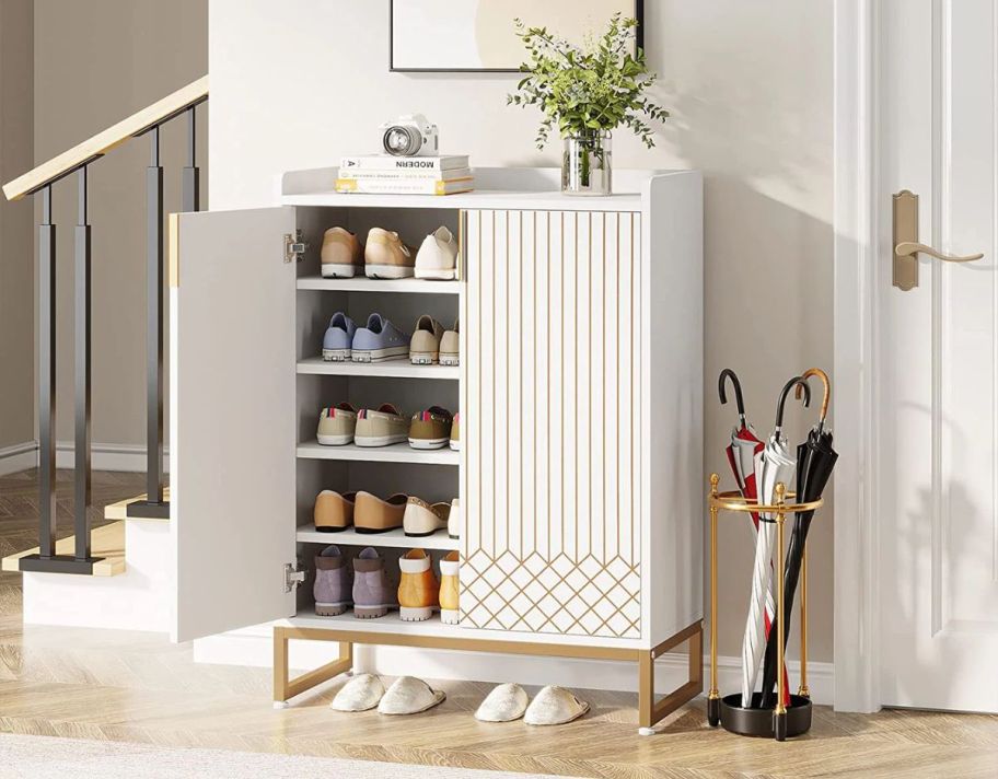 a white shoe cabinet with gold accents
