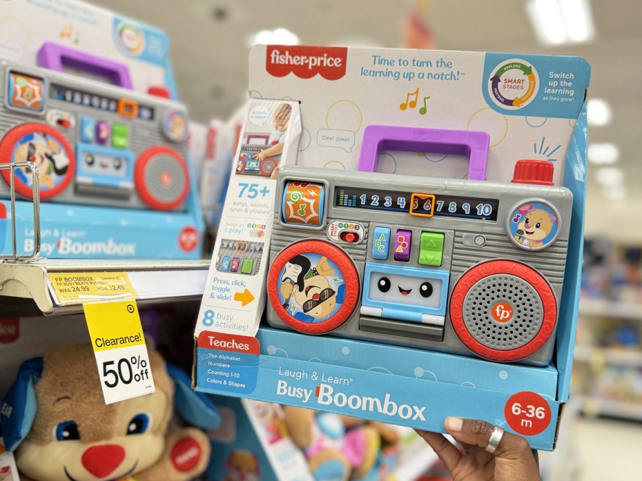 hand holding up Fisher-Price Laugh & Learn Busy Boombox toy in store