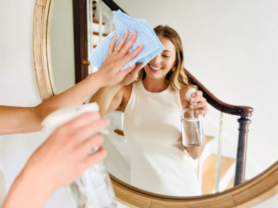 Woman using Force of Nature cleaner to clean a mirror