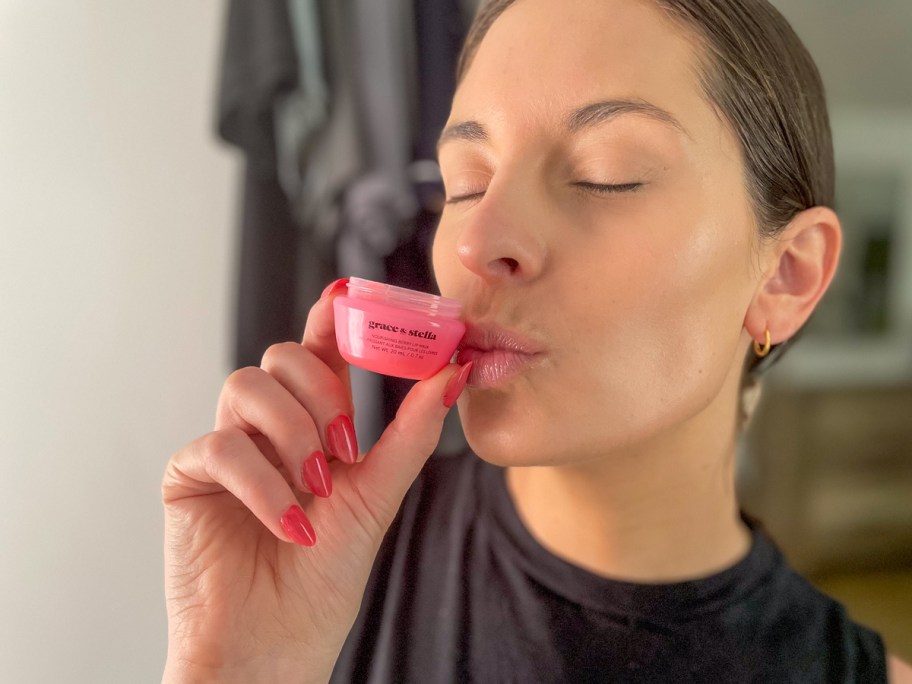 woman holding up and kissing a jar of Grace & Stella Lip Mask