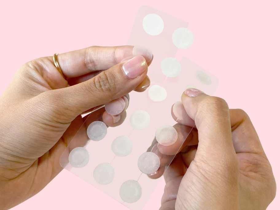 hands holding a set of round pimple patches