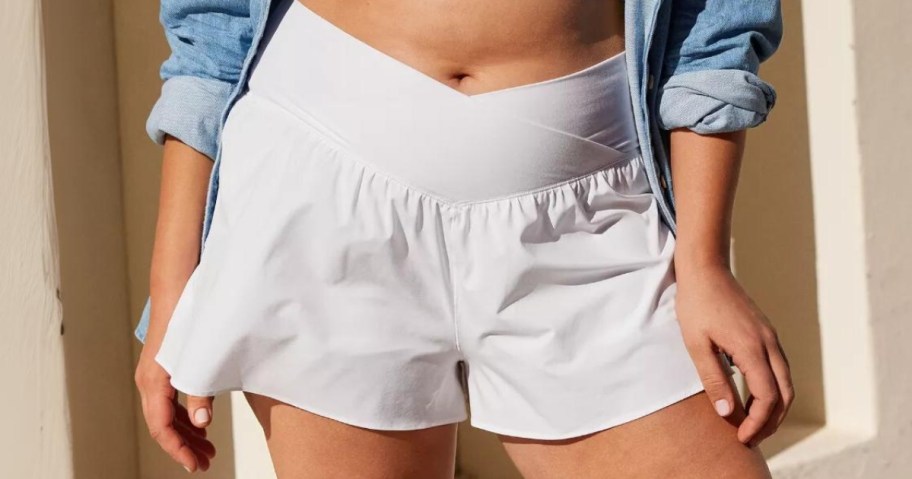 woman wearing a pair of white flowy shorts with a wide crossover band