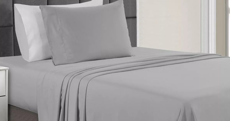 bed with grey sheet set on it