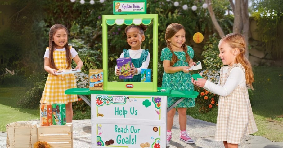little girls playing with a toy Girl Scout Cookie booth and toys