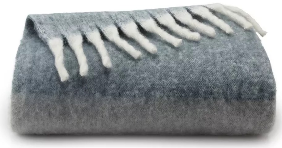 grey mohair blanket with white fringe folded up